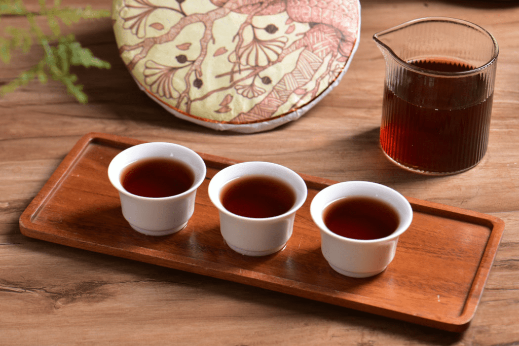 dark reddish brown liquor of shou puerh tea brewed in porcelain cup
