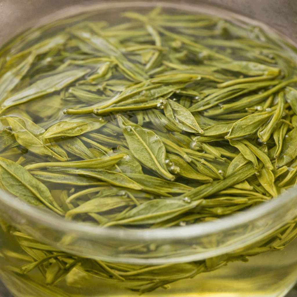 dragon well tea brewed liquor with opened tea leaves