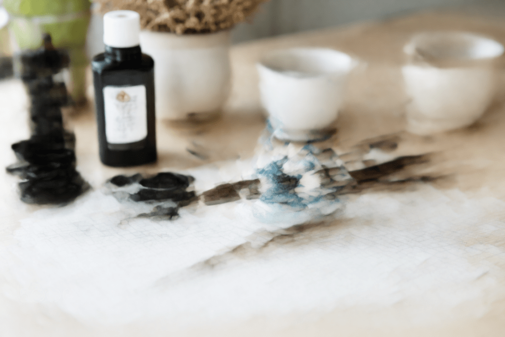 beginner chinese calligraphy setup with brush ink and grid paper in a calm minimal workspace
