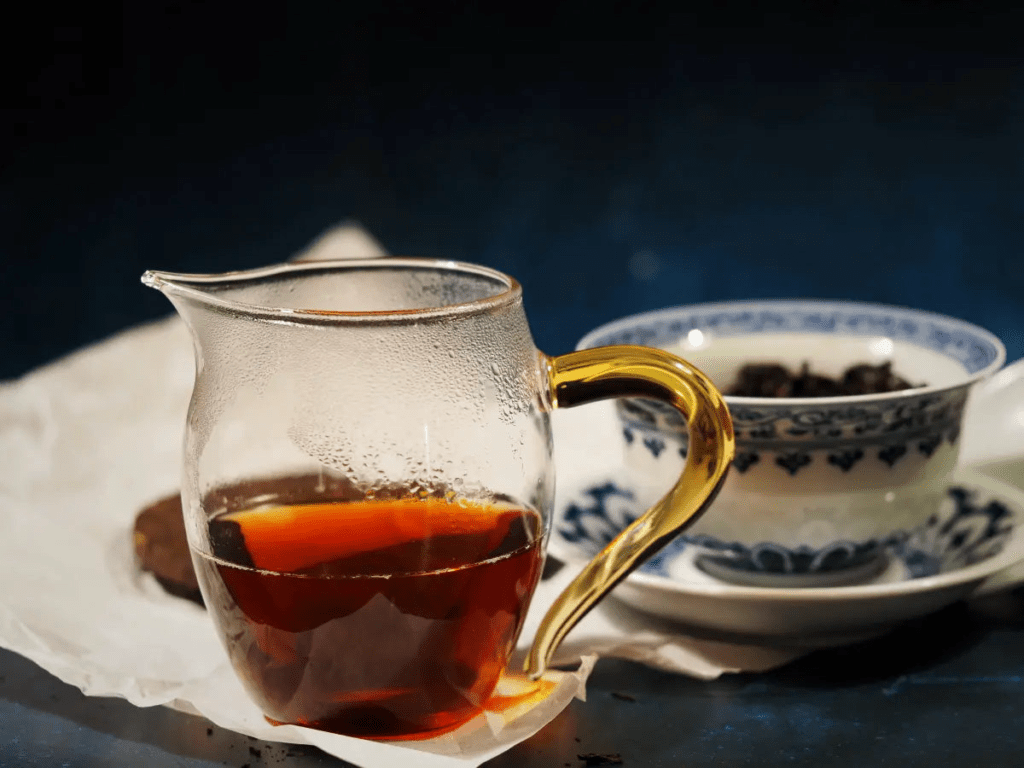aged pu erh tea cake and loose dark tea leaves displayed on a bamboo tea tray