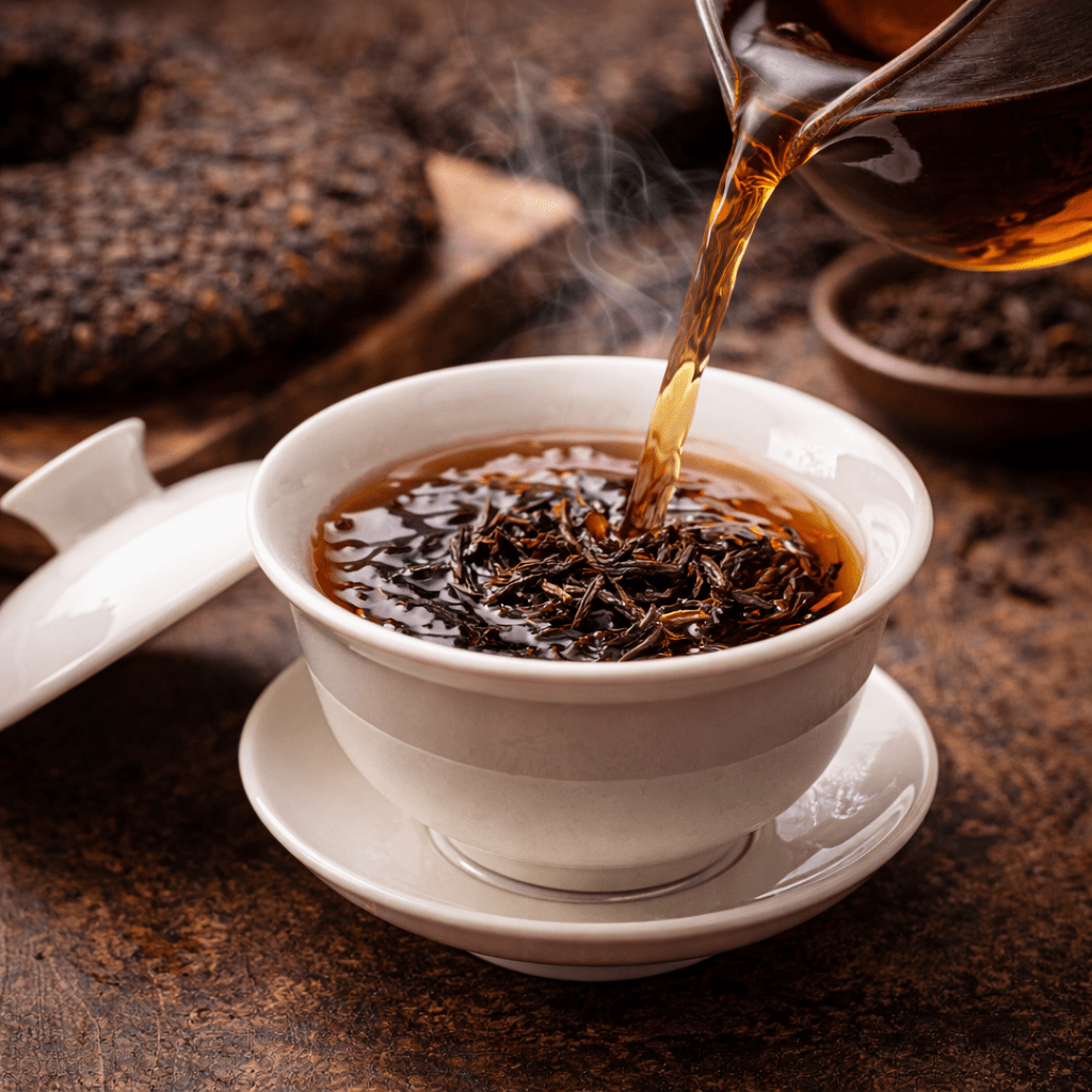 gongfu style brewing of pu erh tea using a gaiwan with hot tea being poured
